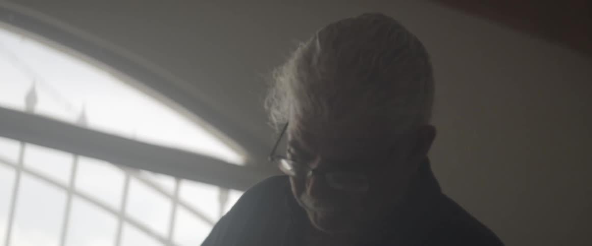 A man is looking down in a dark room