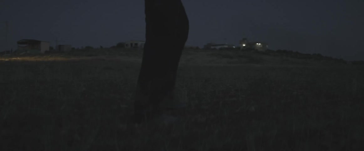 A man walks outside in the evening