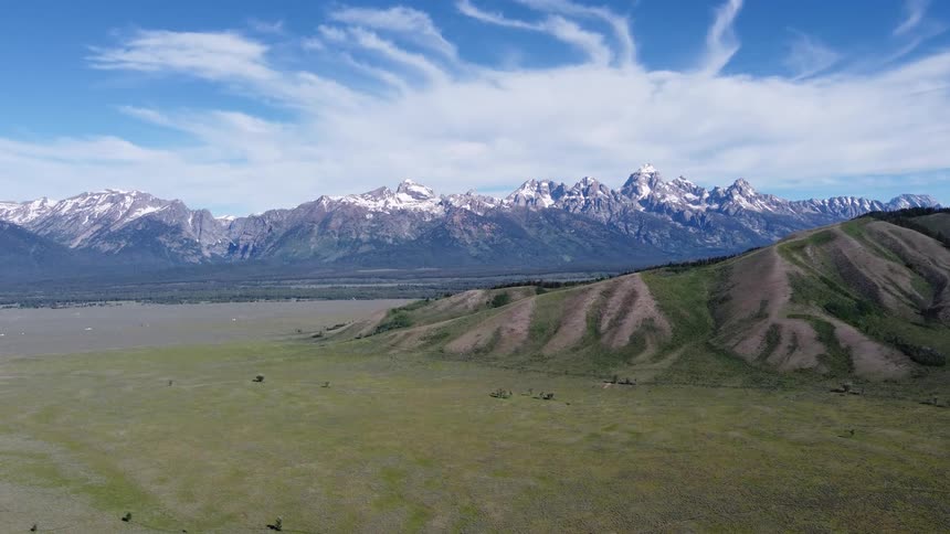 A mountain range sits in the distance while covered in snow