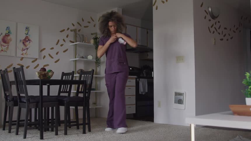 Woman with curly hair walking through the rooms of the house