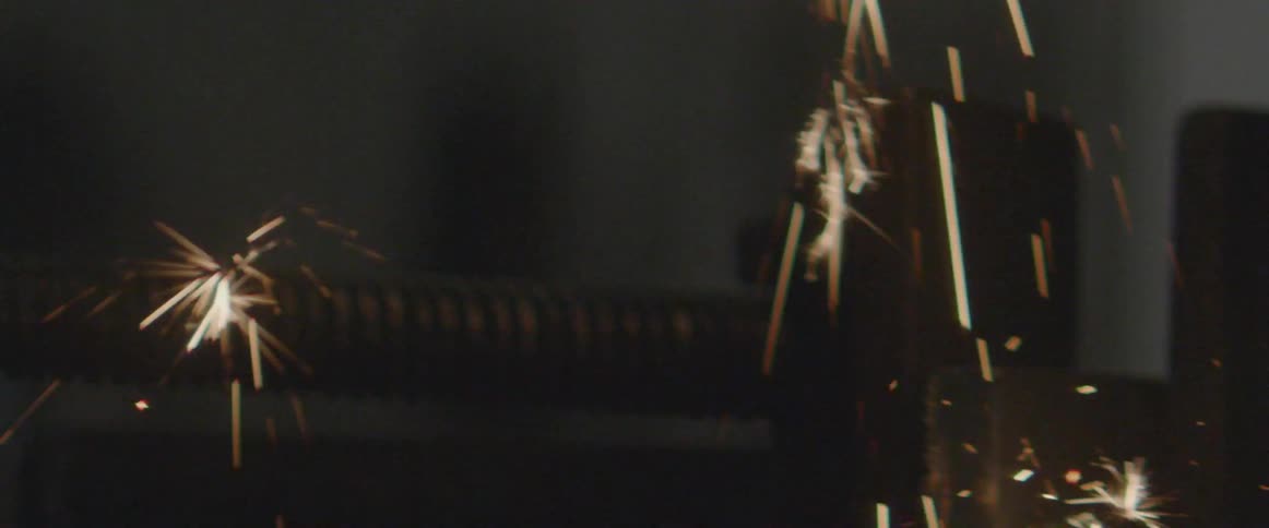 Sparks fly as a man uses a grinder
