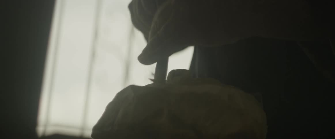 A man works with a chisel and hammer