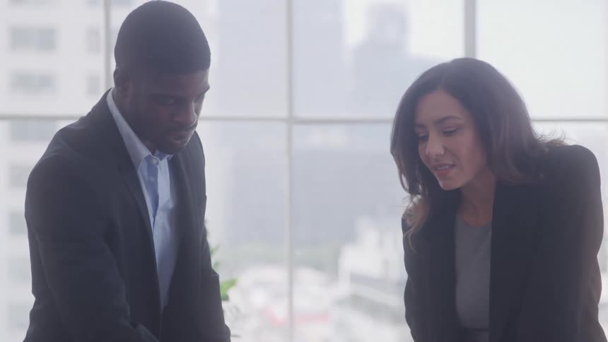 A man talks with a woman by the window in the office