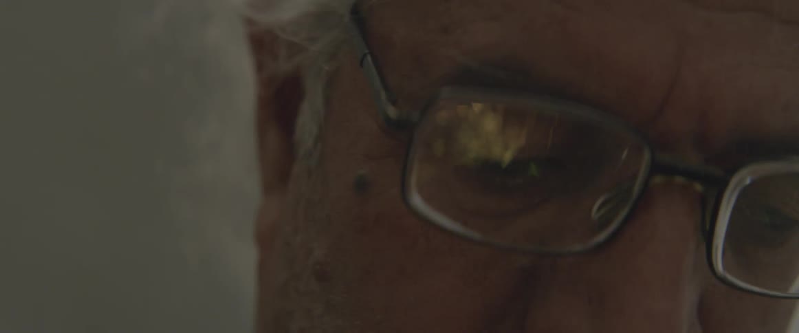 A man wearing glasses looks at sparks