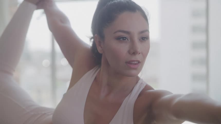 The woman smiles while doing yoga
