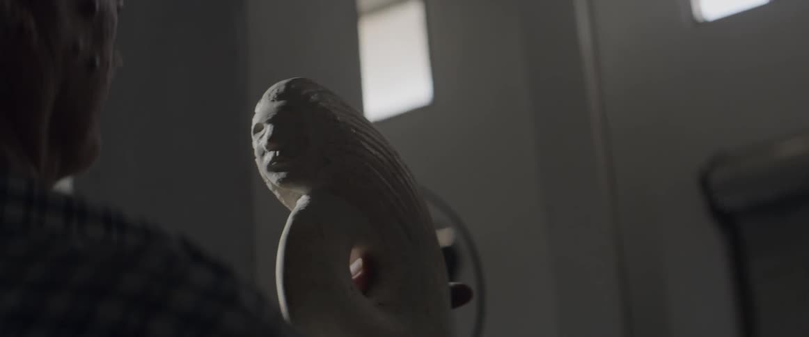 A man is examining a sculpture