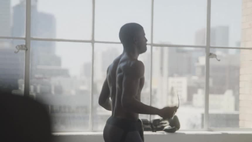 Man in an indoor space jumping rope