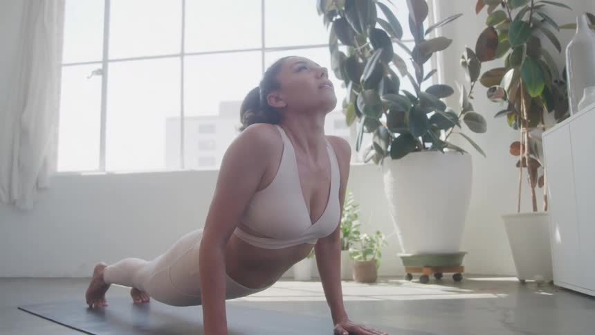 The woman is doing yoga and stretching on the mat