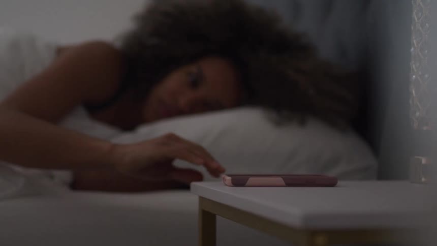A woman is woken up by her cell phone