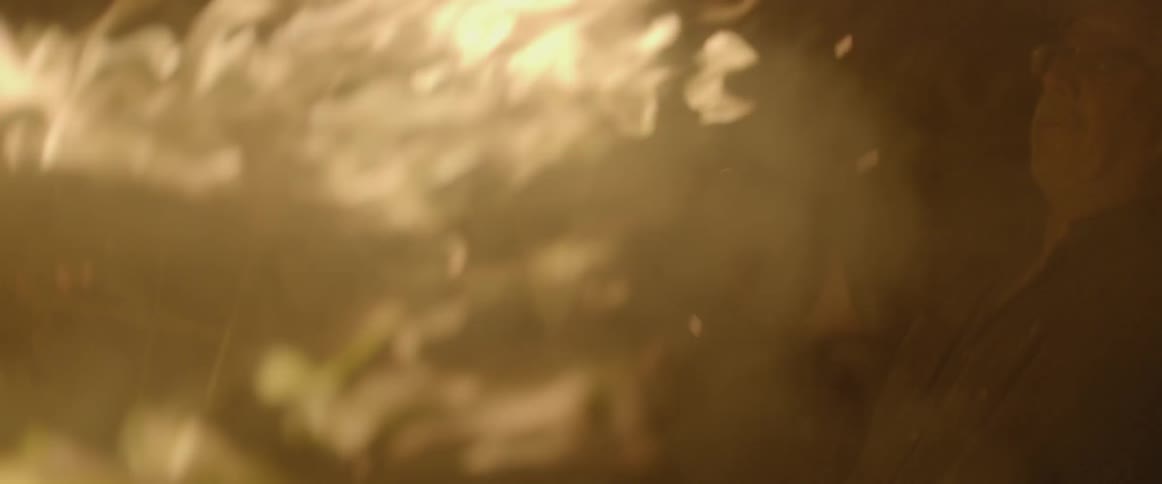 A man pokes a fire with a stick
