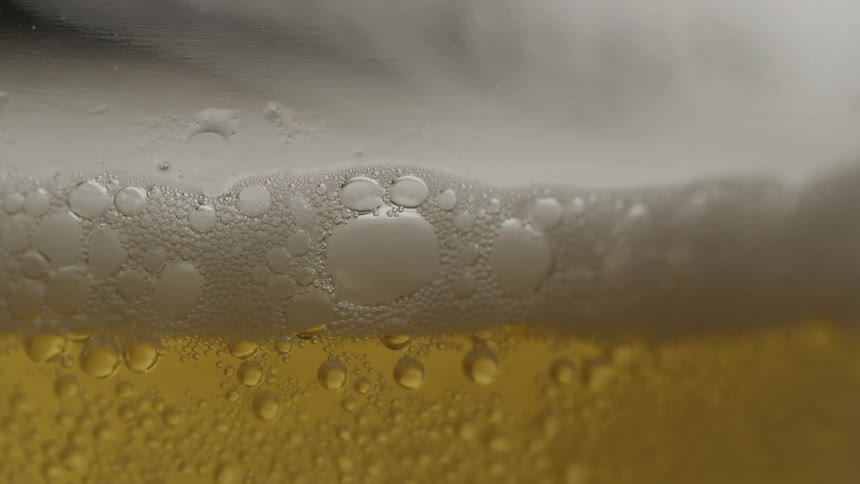 The glass of beer has foam on it