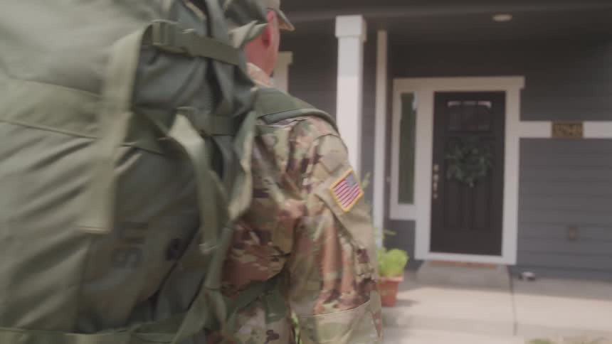 The soldier is walking towards the home