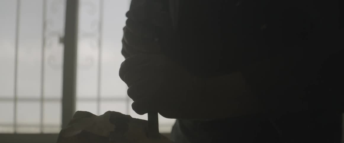 A man works with a chisel and hammer