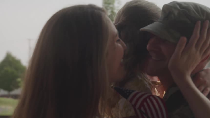 A soldier embracing his family
