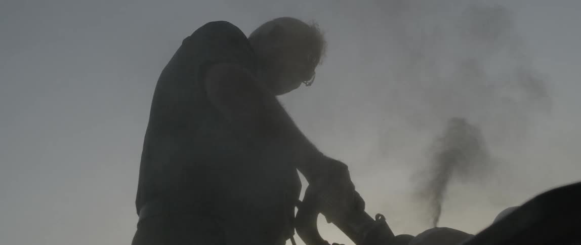 A man is sanding some stone on a rooftop