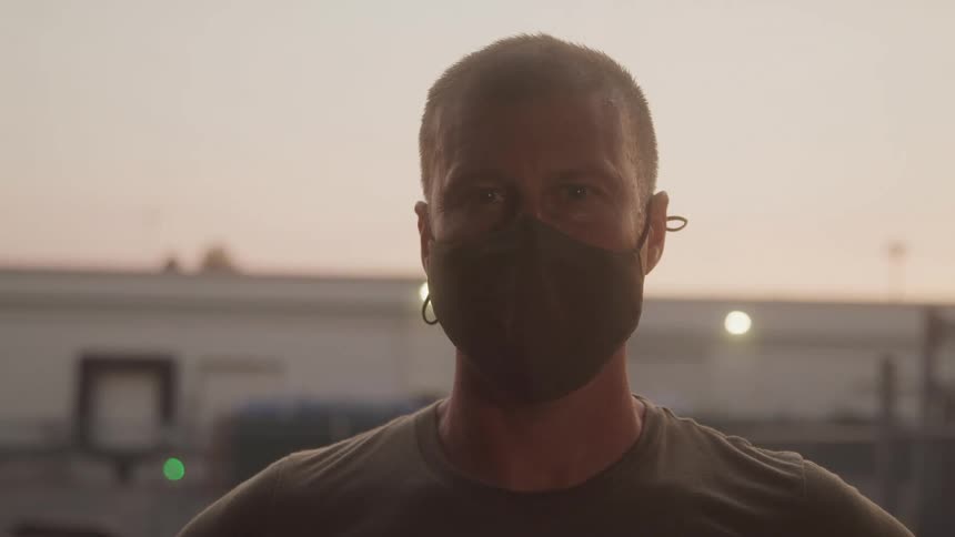 The man is wearing a green mask