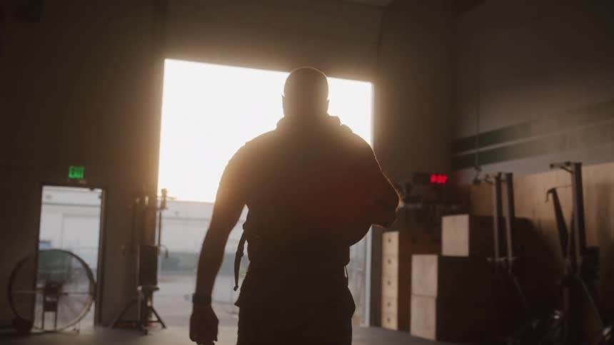 The soldier grabs his bag and exits the gym