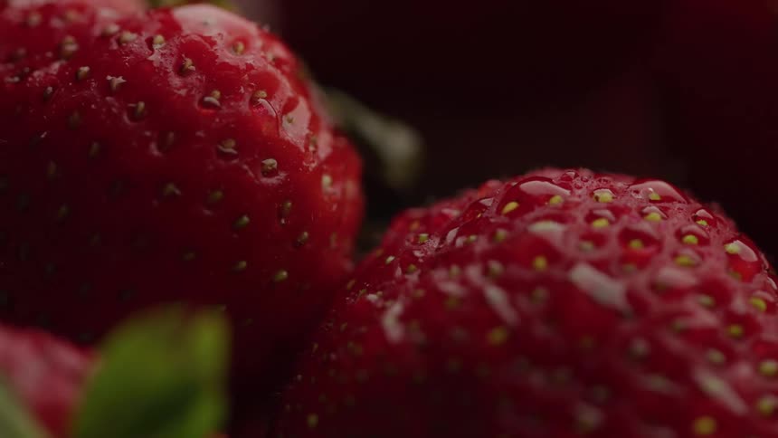 Several strawberries have small drops of water on them