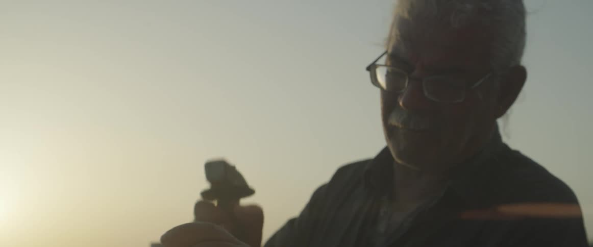 A man is hammering a chisel outside