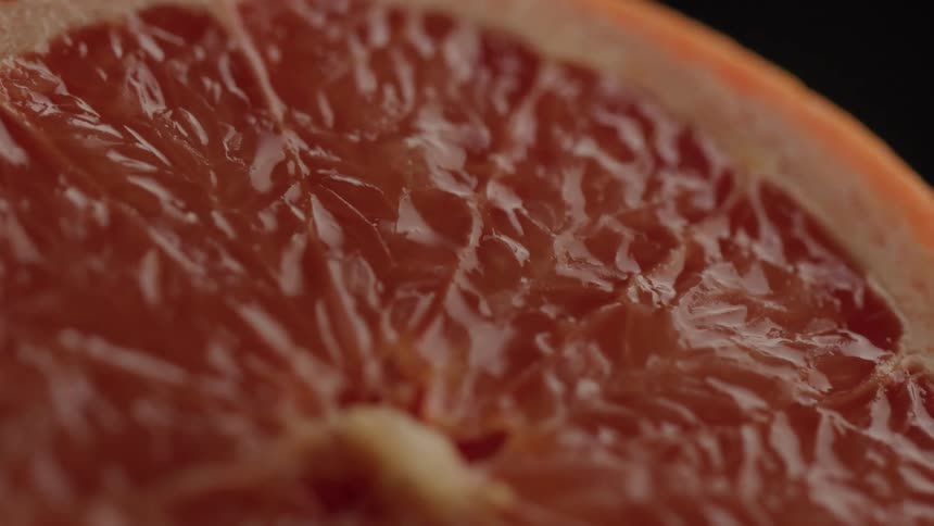 A closeup shot reveals the intricate juicy segments of a freshly cut grapefruit the vibrant redorange flesh of the citrus fruit fills the frame