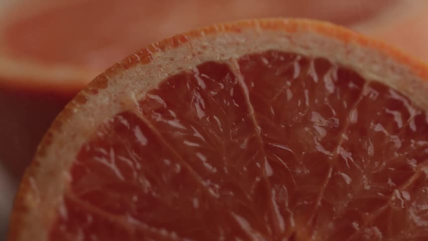 Close up of a sliced grapefruit placed on a rotating surface