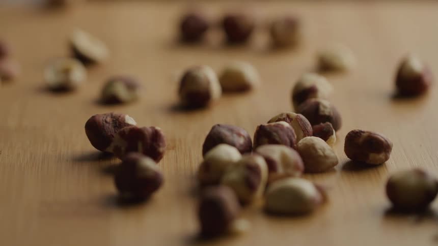 Hazelnuts scattered on a wooden surface in closeup