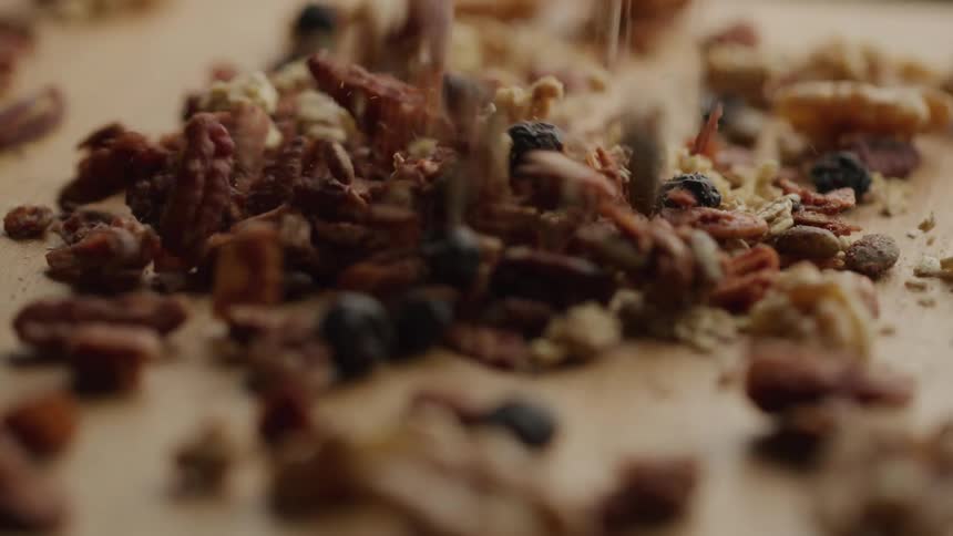 Nuts and fruit fall onto a flat surface