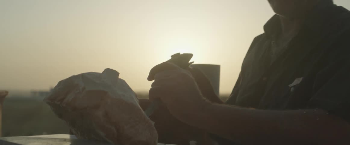 A man works with a chisel and hammer