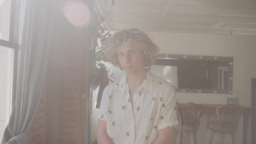 Man with curly hair in a room of the house