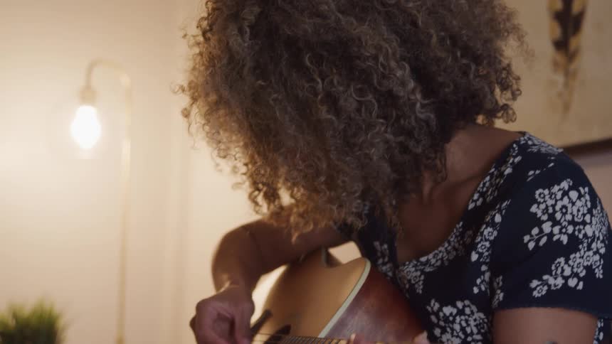 Woman sitting playing guitar