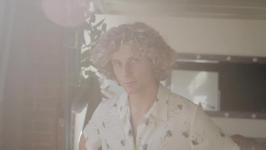 Curlyhaired man in an indoor space