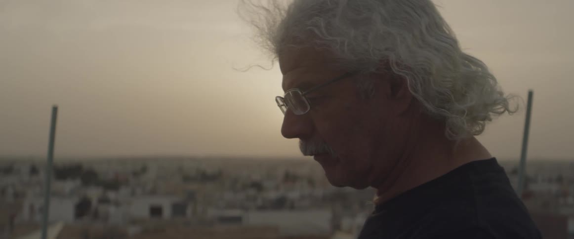 A man looks down on a rooftop