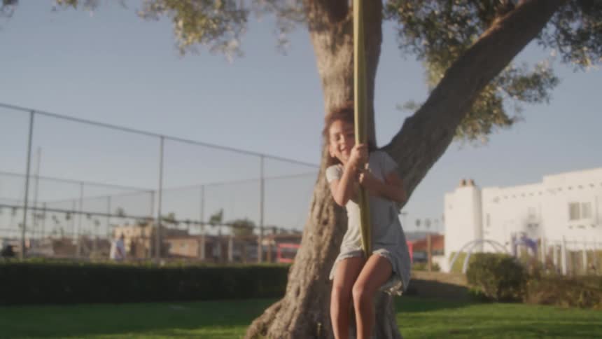 The girl is smiling while swinging back and forth