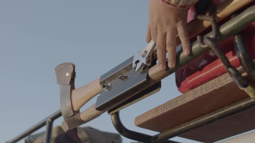 Person uses wrench to loosen a bolt on a rack