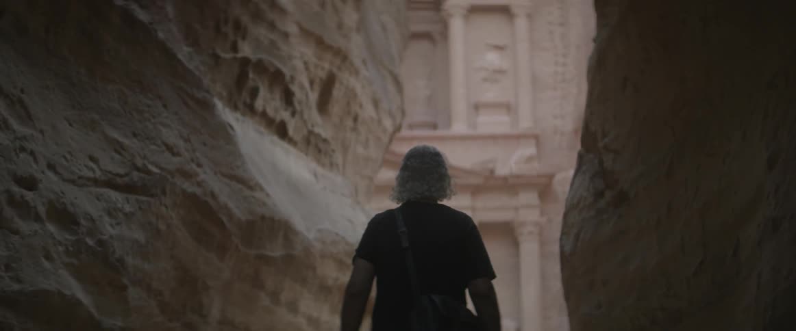 A man walks toward an ancient building