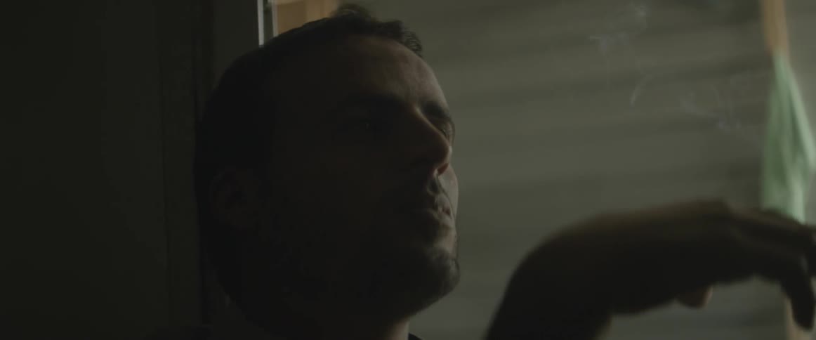 A man sits and smokes a cigarette