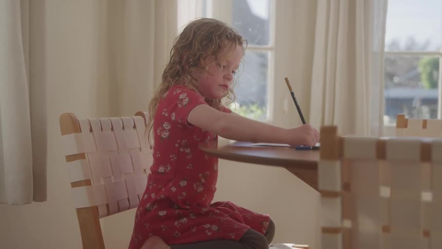 The child is drawing at home