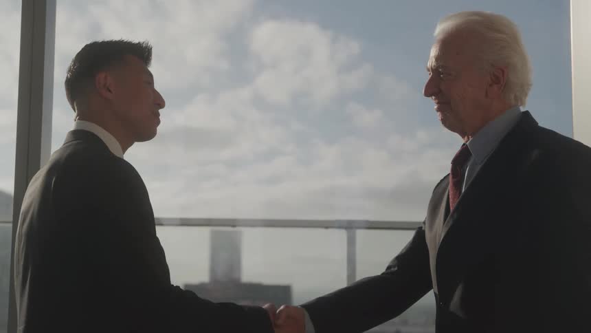 Two men shake hands