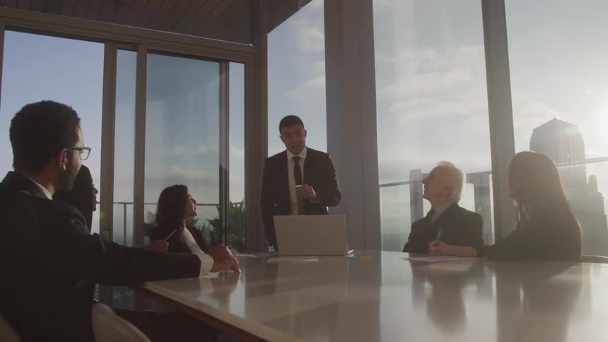 A man presents to colleagues in a high rise conference room
