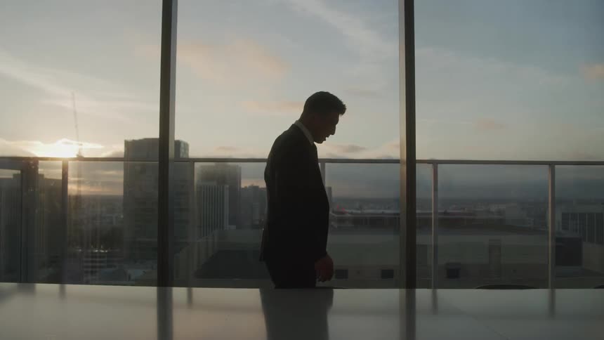 Man in suit in an office room checking documents papers and throwing them up