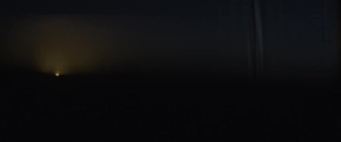 A light shines up ahead through a car window