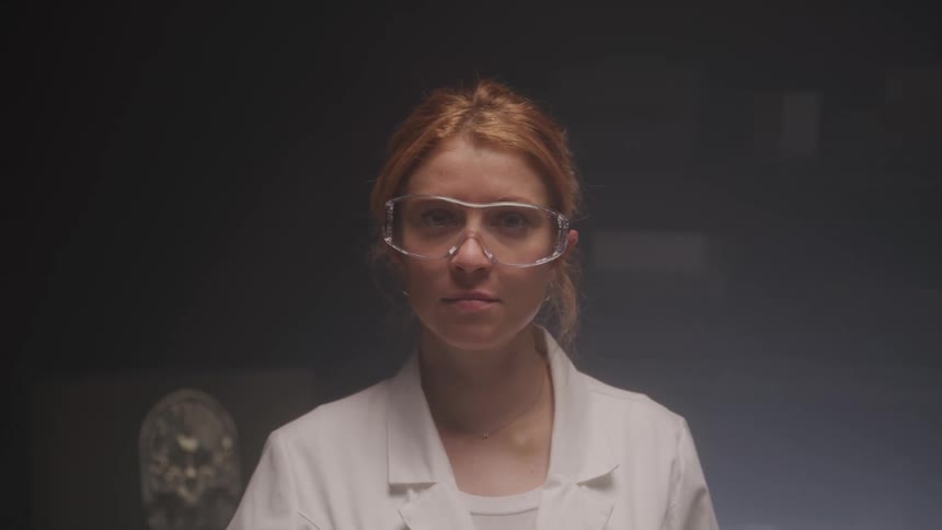 Portrait of a woman in a white coat and glasses in a laboratory