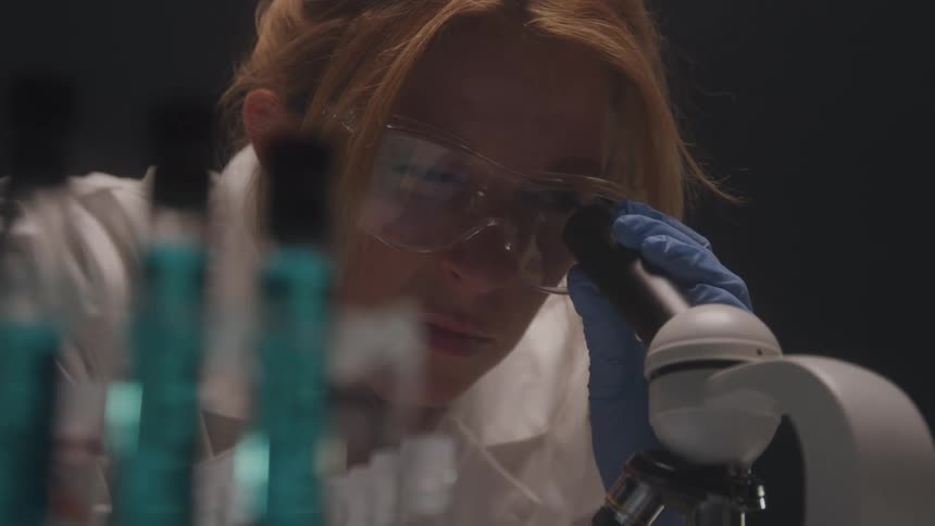 Female scientist looking through a microscope