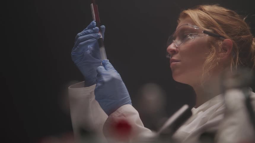 Blonde woman working with tubes in a laboratory