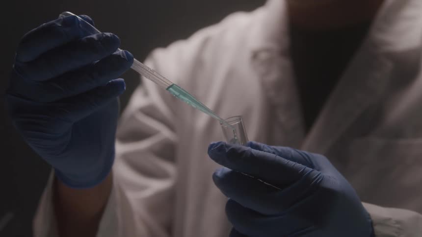 Scientist tests liquid with pipette in lab