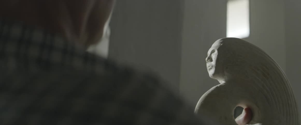A man holds up a carving