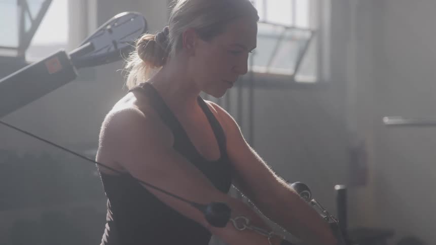 Blonde woman doing weight training in a gym