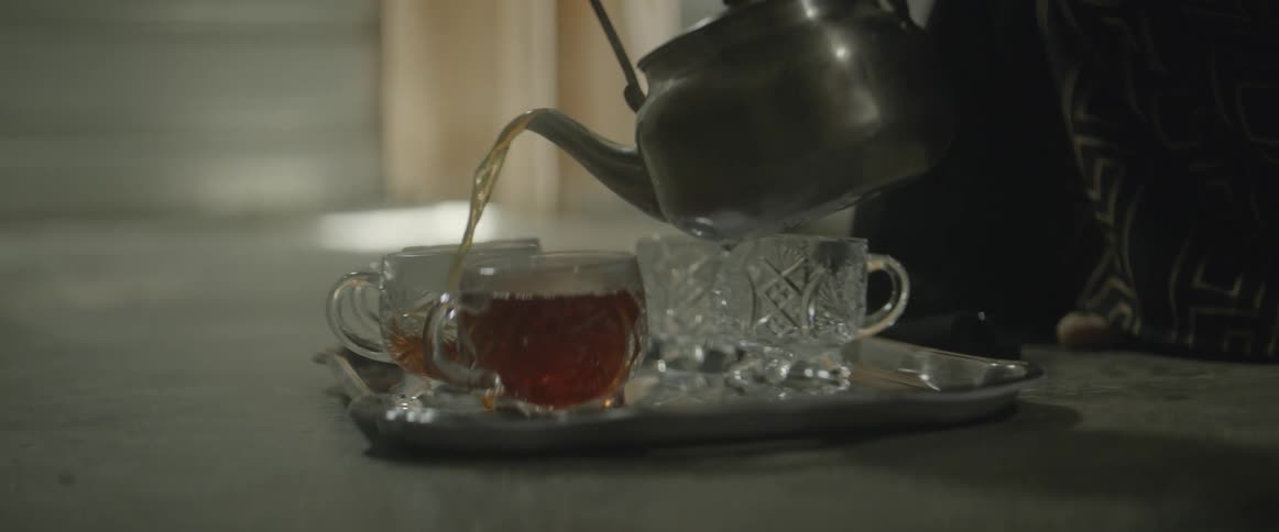 Hot tea is poured into crystal glasses
