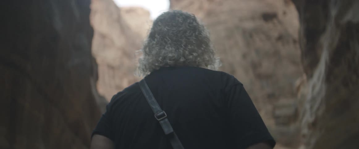 A man is walking along a deep cavern