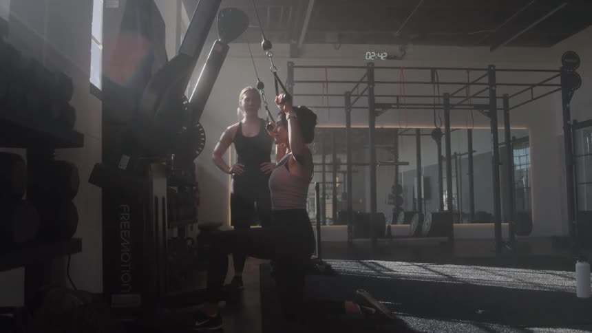 Two women are exercising together in the gym